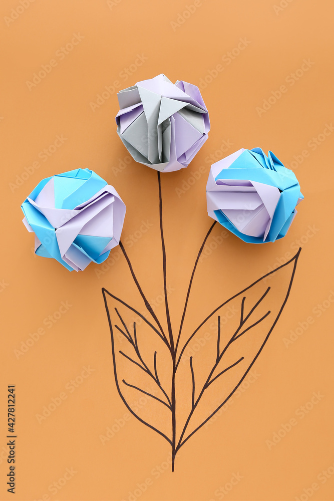 Origami flowers on color background. Concept of uniqueness