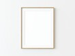 © Washdog - Light wood thin rectangular vertical frame hanging on a white textured wall mockup, Flat lay, top view, 3D illustration
