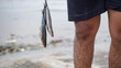 © HumbaFrame - Close up fisherman getting fish from his fishing in beach