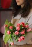 Fototapeta  - Woman holding beautiful blossoming mono bouquet of fresh tulips flowers. Beautiful flowers.