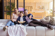 © deniskomarov - Smiling laughing parent showing funny video to son on television. Parent and son watching comedy movie on tv-set at home. Happy family sitting on comfort sofa. Cozy evening in living room interior