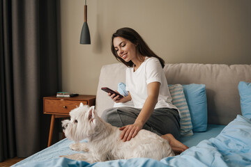 Happy young woman playing with her dog