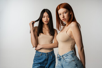 Wall Mural - Two young multiethnic women standing posing together