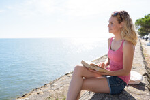 Close Up Of A Woman Reading Near The Sea