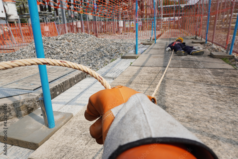 Rescuers' hands are pulling a rope to save worker an electric shock ...