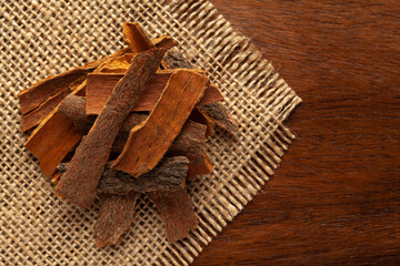 Wall Mural - close-up of Organic cinnamon ( Cinnamomum Verum) or dalchini on the wooden top background and jute mat. Pile of Indian Aromatic Spice.