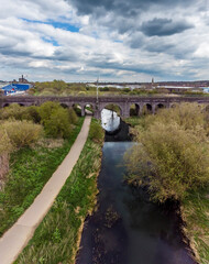 Wall Mural - An aerial view looking along the River Nene towards the Far Cotton Railway viaduct in Northampton, UK on a Spring day