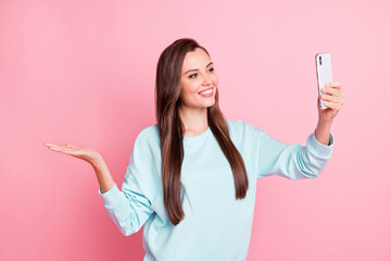 Sticker - Photo of brown haired girl hold hand copyspace make selfie wear blue sweater isolated on pink color background