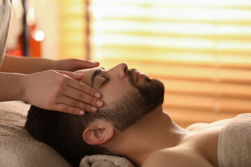 Sticker - Young man receiving facial massage in beauty salon