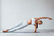 © standret - Doing yoga exercises. Woman with sportive slim body type in underwear that is in the studio