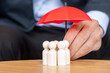 Businessman hand holding umbrella and cover man wooden from crowd of employees. People, Business, Human resource management, Life Insurance, Teamwork and leadership Concepts