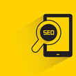 smartphone and magnifier glass seo with shadow on yellow background