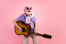Photo Portrait Of Funky Happy Grandpa Playing Guitar Wearing Star Sunglass Isolated On Pastel Pink Color Background