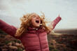 © StratfordProductions - Close-up of a beautiful woman on mountain trail with her hair flying and hands outstretched with mouth open