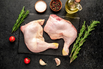 raw chicken legs with spices on a stone background