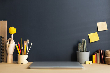 Wall Mural - Trendy home office with laptop and stationery, green plants and books around, Homeschooling concept. Trendy, creative desk.	
