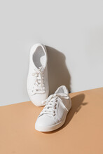 White Women's New Gumshoes On Grey And Beige Background. Washing And Cleaning Concept. Vertical Format. Close Up.