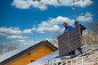© mmphoto - Installing solar photovoltaic panel system. Solar panel technician installing solar panels on roof. Alternative energy ecological concept.