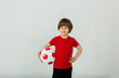 a small soccer player holds a soccer ball on a white background with space for text