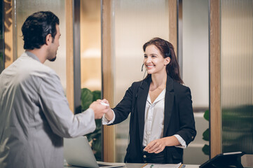 young man handing over a key card to woman Receptionist  at hotel front desk