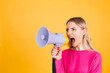 © Анастасия Каргаполов - Pretty european woman in pink  blouse on yellow background angry serious  shouting in megaphone ask for attention