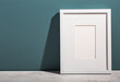 © Bidwell Studio - A white picture frame leans on an aegean teal painted wall.