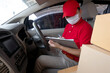 © photobuay - Delivery man employee in red cap t-shirt uniform mask checking preparing packages to deliver to customers who order online during the coronavirus or covid-19