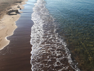 Wall Mural - Sandy beach and surf line on a sunny, cloudless day.