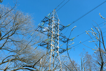 High-voltage towers in the forest. High voltage transmission line under a blue sky