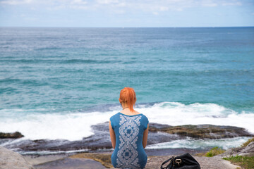 Wall Mural - a woman sitting facing the bay in sydnay australia