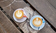 High angle shot of two cups of delicious latte coffees on a wooden surface