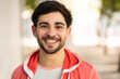 © Mego-studio - Close-up of young man smiling outdoors.