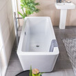 Front view of a white tub in bright bathroom with tiled floor and walls