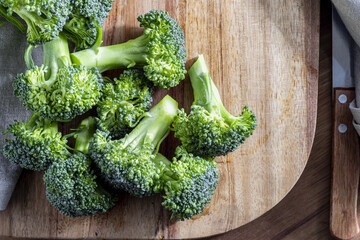 Wall Mural - Close-up of raw, fresh broccoli (Brécol, brócolli, bróqui, broccoli brote, brassica oleracea) stalks with drops of water in the preparation process. With copy space. Top view. Mediterranean diet food.