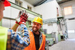 © Robert Kneschke - Zwei Arbeiter begrüßen sich mit High Five in Fabrik