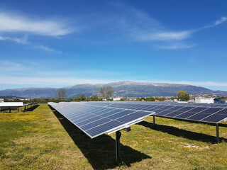 Poster - solar panels solar energy in a green meadow and blue bright sky