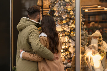 Canvas Print - Lovely couple near store decorated for Christmas outdoors, back view