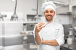 © Syda Productions - food cooking, asian cuisine and people concept - happy smiling male chef in toque holding something with chopsticks over restaurant kitchen background (focus on chopsticks)