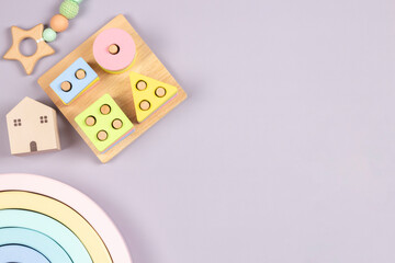 Baby kid toys on light gray background. Sustainable early childhood development baby stuff and natural pastel color wooden toys. Top view, flat lay