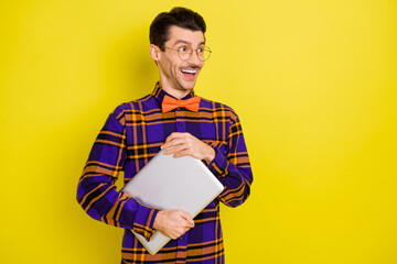 Sticker - Photo of young excited man happy positive smile look empty space hold laptop isolated over yellow color background