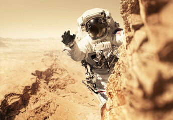 Wall Mural - astronaut martian is on a mission to the red planet and climbs up a mountain on a rock. space man co