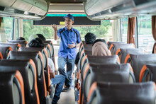 A Bus Crew In Uniform And A Hat Briefs The Passengers On The Bus Before Leaving