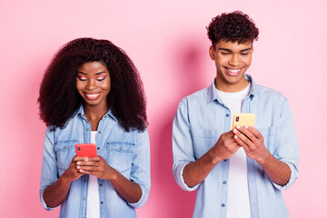 Poster - Portrait of beautiful handsome trendy friends friendship using device blogging isolated on pink pastel color background