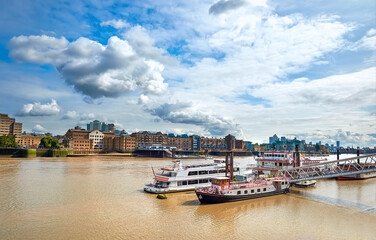 Fototapete - River Thames in East London on a bright sunny day with passenger boats on the foreground. Wappping and St. Katharine's Docks are on the other shore.