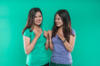 © Odua Images - Happy expression of Asian twins with clenched fists on green background