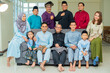 © faizzaki - Eid Mubarak celebration moment, family photo at the sofa wearing traditional cloth
