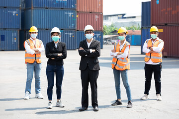 portrait factory workers team wearing medical face mask for protect virus with containers warehouse storage