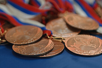 Bronze sports medals on a ribbon with a flag