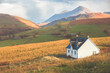 A lone traditional Scottish Highlands white croft house cottage in a rural mountain landscape countryside with Glamaig Peak and the Red Cuillins on the Isle of Skye, Scotland.