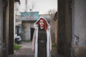 Poster - Young Caucasian female wearing a green dress and a jacket posing outdoors